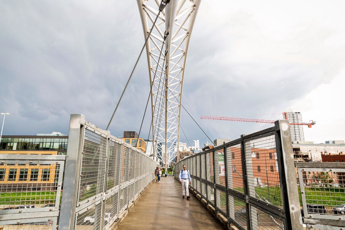 Pedestrian suspension bridge connecting LoHi to downtown Denver with the skyline beyond