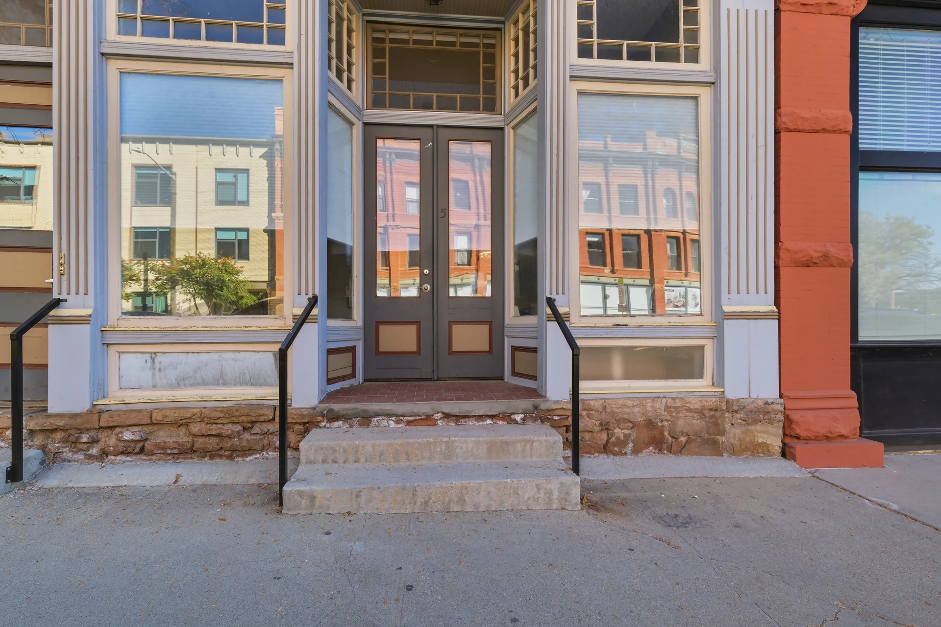Front door and tall storefront windows in the historic brick façade